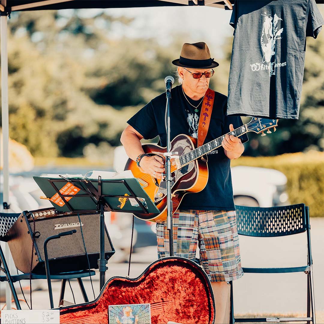 Musician playing guitar at the qualicum beach farmers market this weekend.